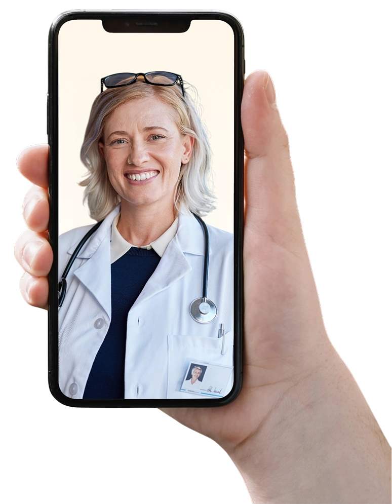 A hand holding a smartphone displaying a video call with a smiling doctor wearing a white coat, stethoscope, and glasses resting on her head.